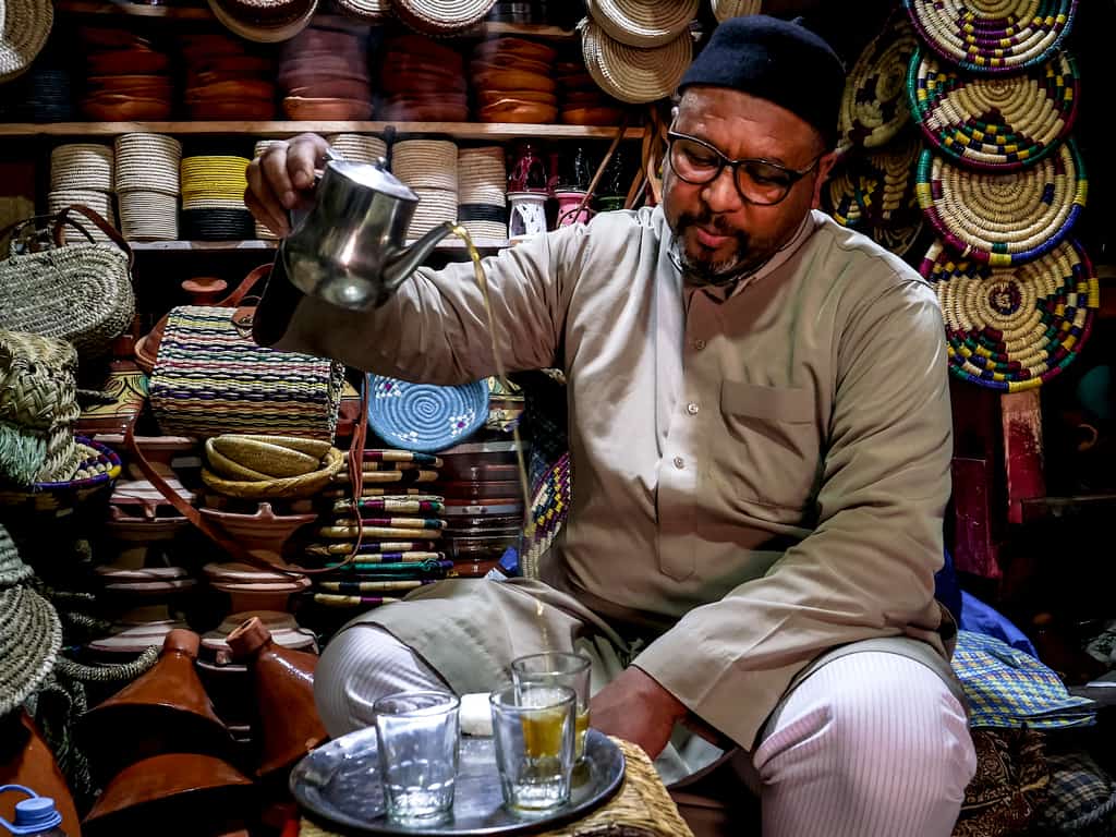 Photography tips for Morocco - Man pourring tea in Essaouira - Journal of Nomads