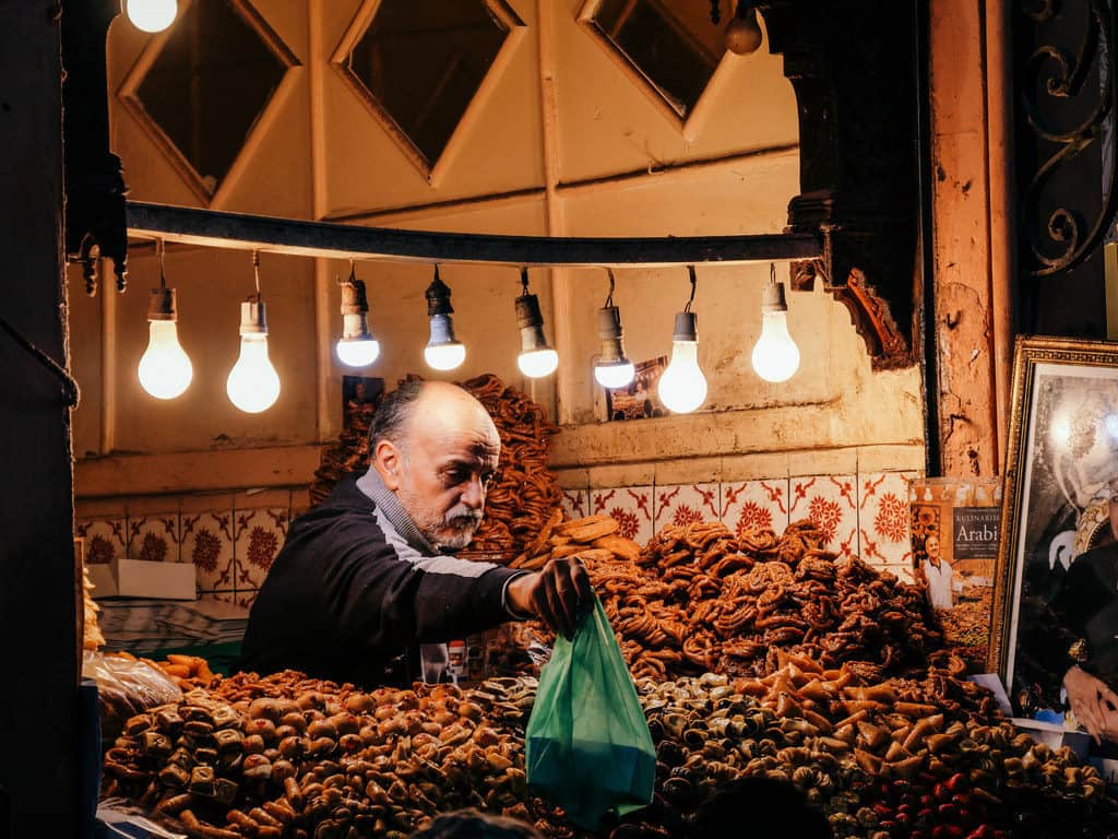 Morocco Itinerary 2026: 3 Best Routes for a Morocco trip Through Imperial Cities, Atlas Mountains & Sahara 57 man selling sweets Marrakesh Morocco - journal of nomads