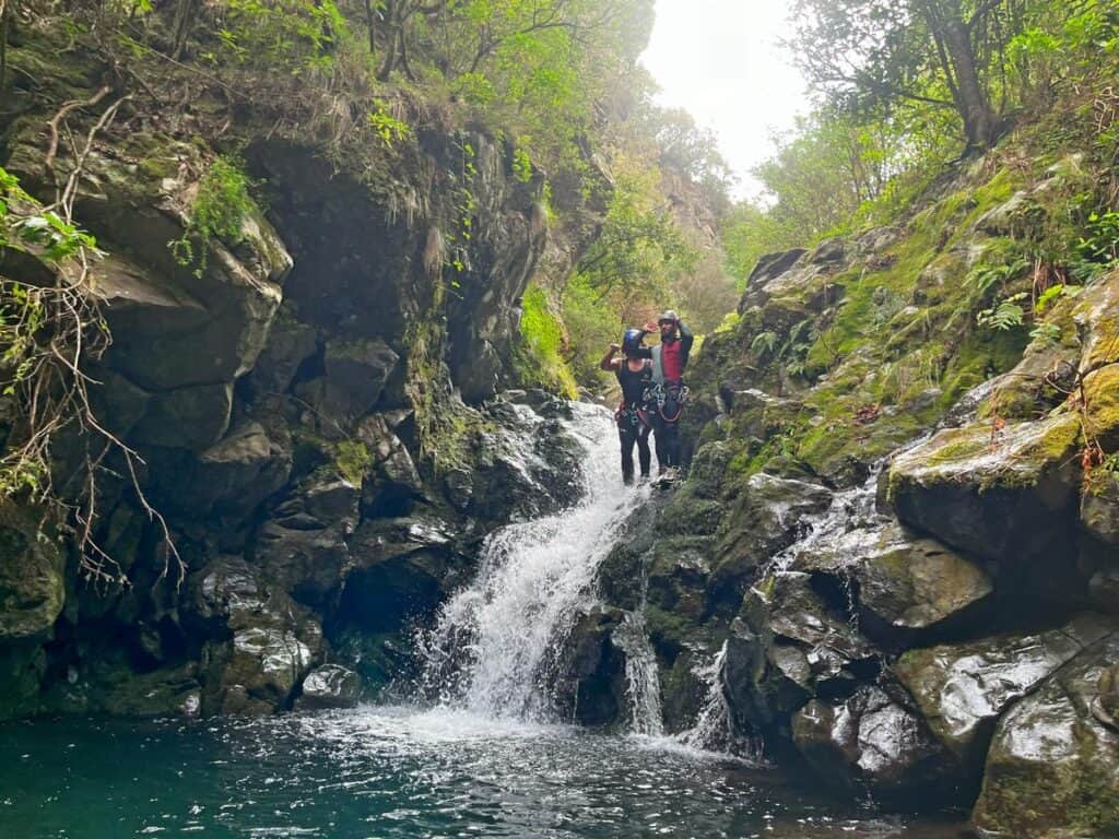 Canyoning in Madeira - Journal of Nomads. Two canyon guides from Epic Madeira about to jump down waterfalls near Ribeiro Frio.
