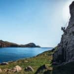 Climbing in Madeira - Journal of Nomads. Two rock climbing guides ascend a sport climbing route at a crag near São Lourenço trail, Madeira island, Portugal.